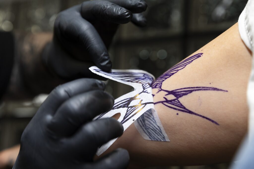 A close-up image of a person's arm showcasing a unique tattoo design incorporating personal symbols and meaningful details.